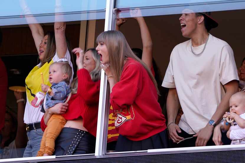 Taylor Swift celebrates as she watches from a suite during the first half of an NFL football...