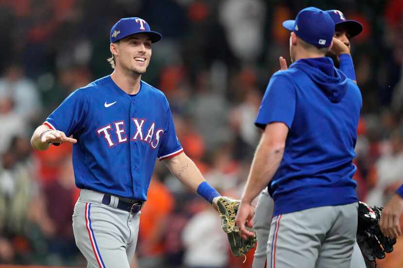 Texas Rangers left fielder Evan Carter (left) is congratulated by teammates after their win...