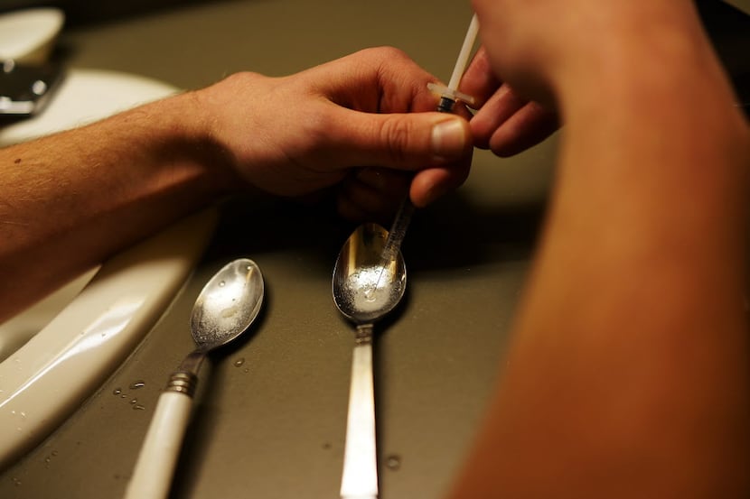 A drug user prepares heroin for injection.