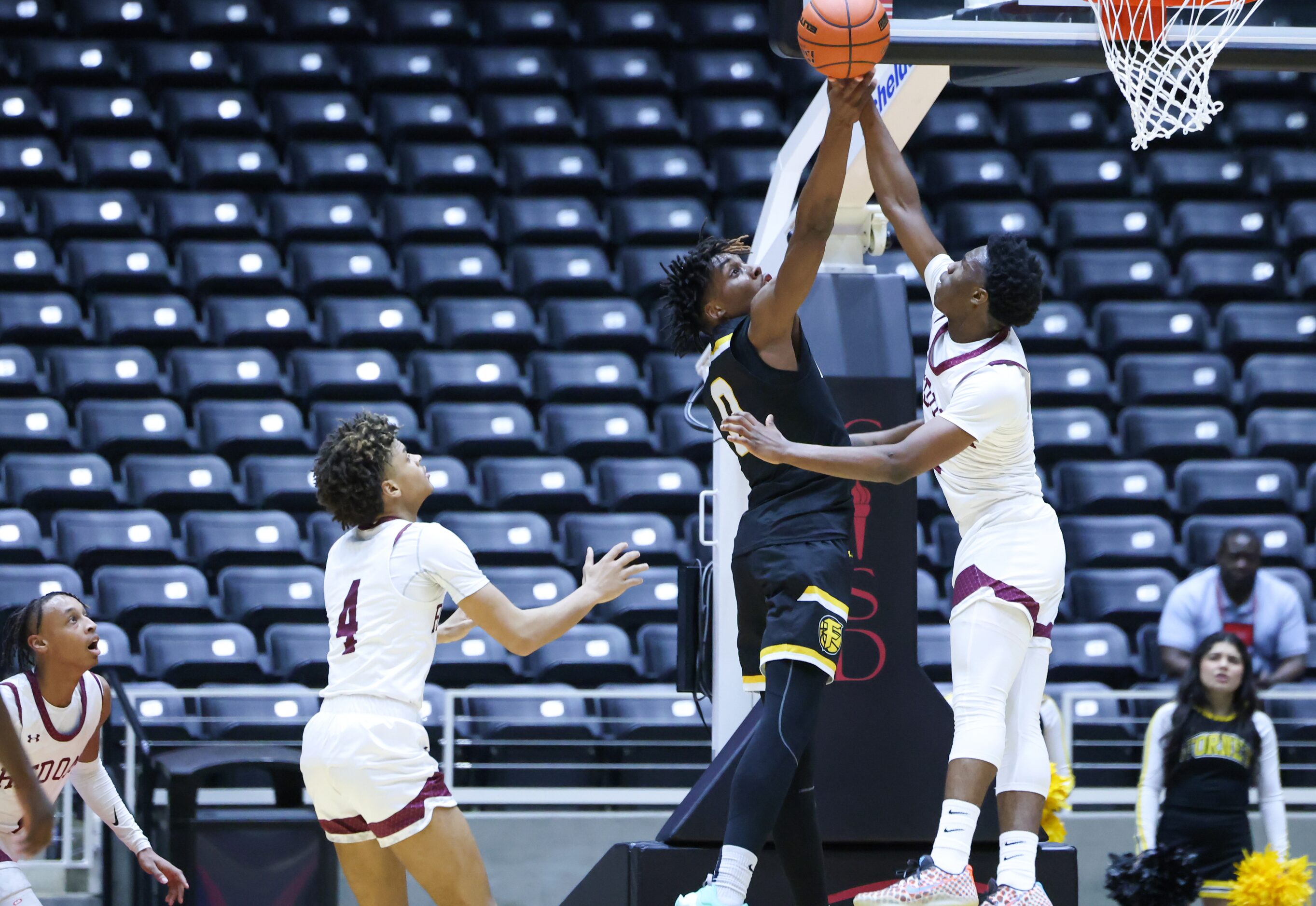 Forney senior forward Ronnie Harrison (0, left) is blocked from a shot at the net by Red Oak...