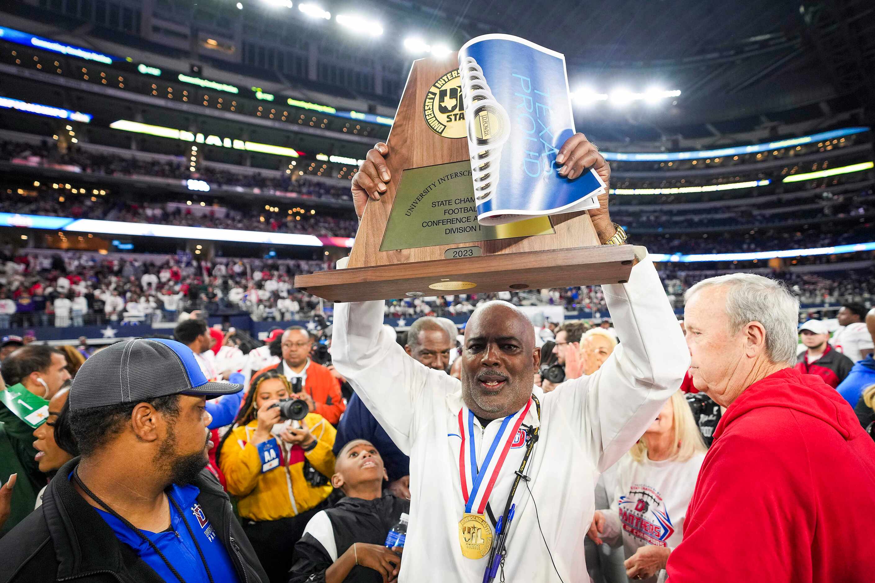 Duncanville head coach Reginald Samples lifts the championship trophy after a victory over...