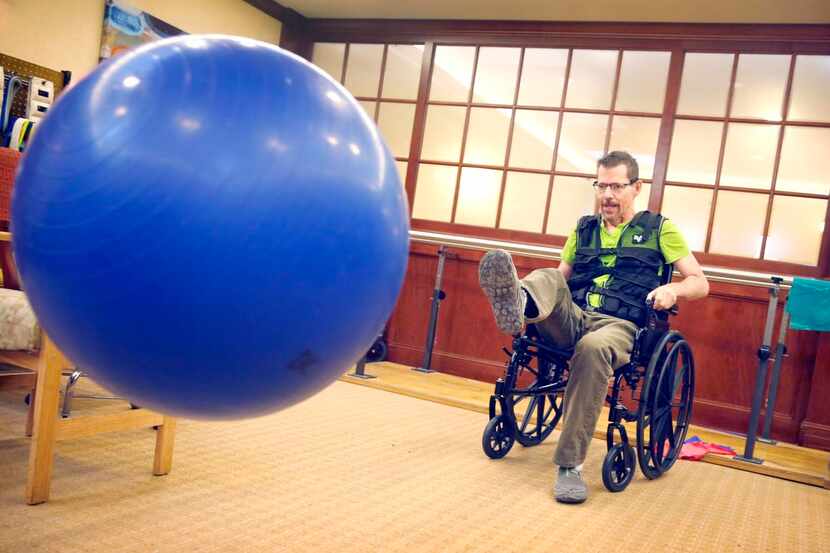 Bruce Monroe kicks an exercise ball to strengthen his motor skills at the rehab facility...