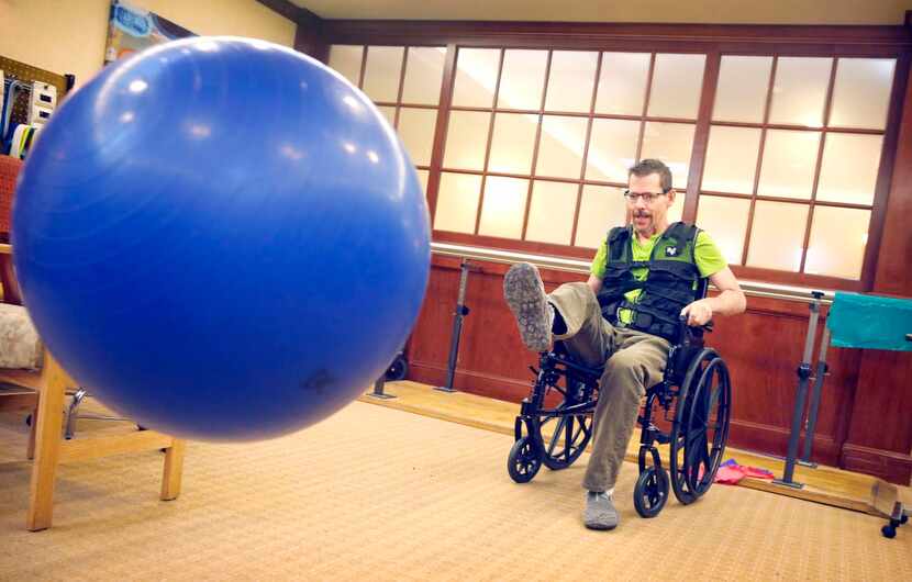 
Bruce Monroe kicks an exercise ball to strengthen his motor skills at the rehab facility...