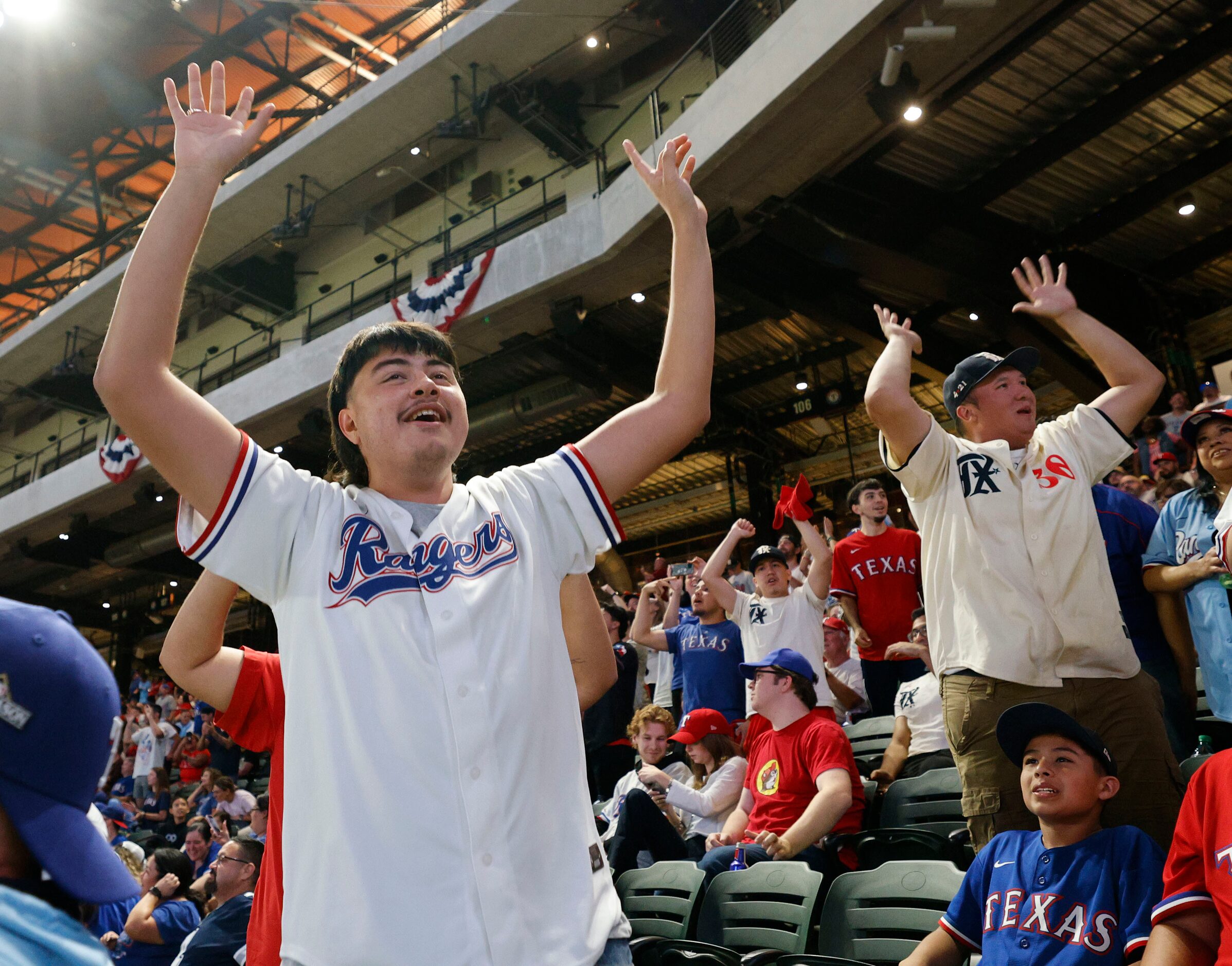 Texas Rangers fan Anthony Vela of Arlington, left, reacts during a Game 7 watch party of the...