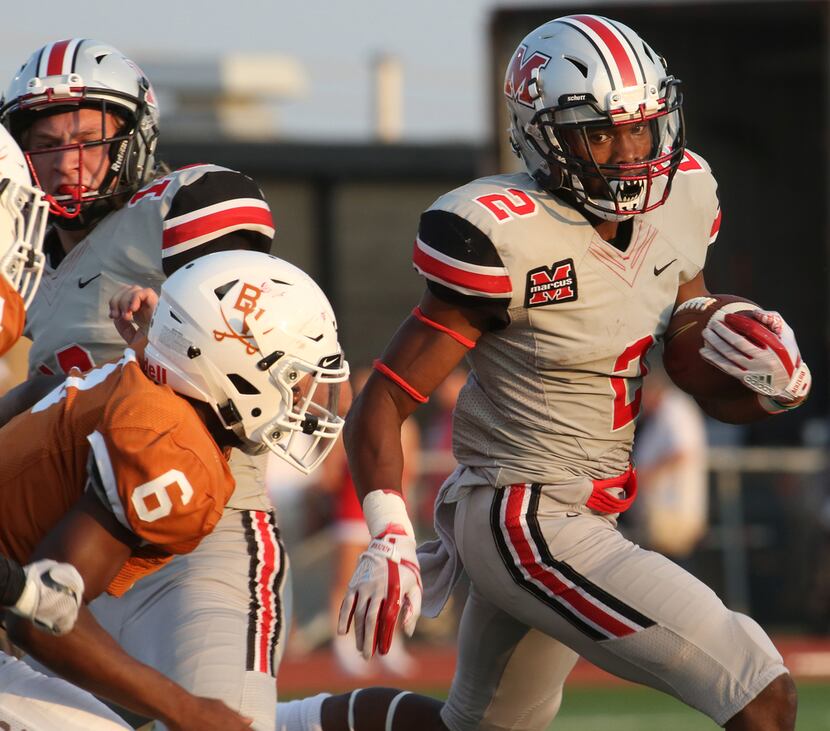 Flower Mound Marcus running back Justin Dinka (2) carries for a first down as Arlington...