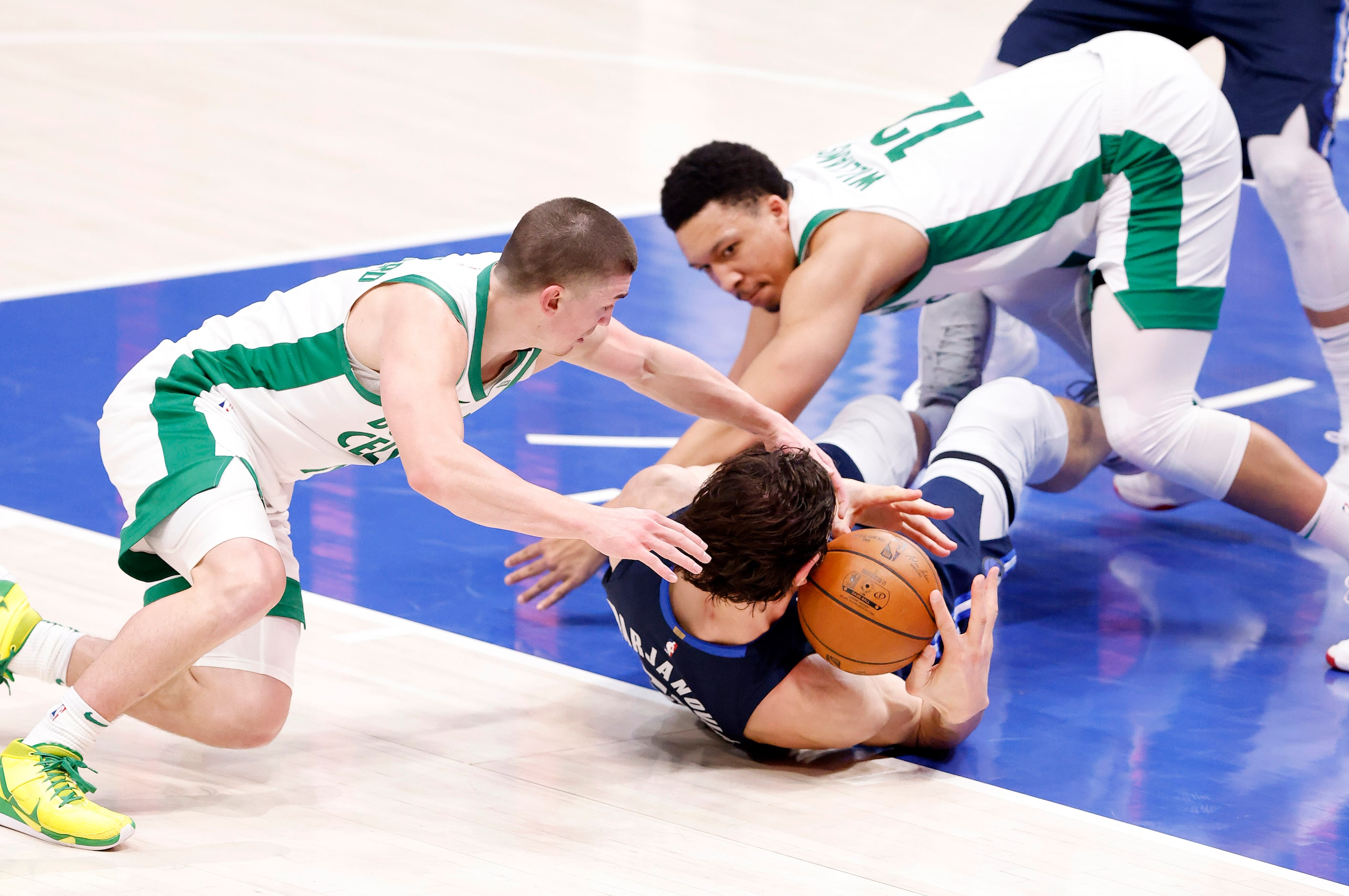 Boston Celtics guard Payton Pritchard (11) and forward Grant Williams (12) go for the ball...