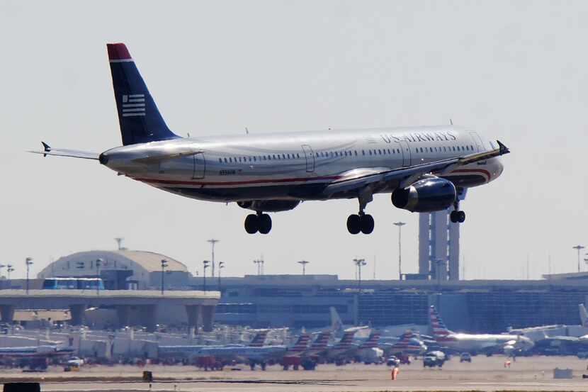  With American Airlines jets lined up behind, a US Airways Airbus A321 lands last month at...