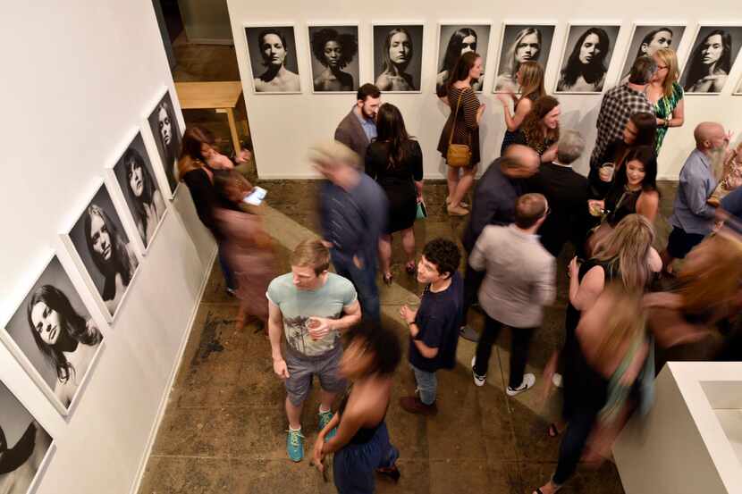 People are blurred with a slow camera shutter as they mingle during opening night of Fredrik...
