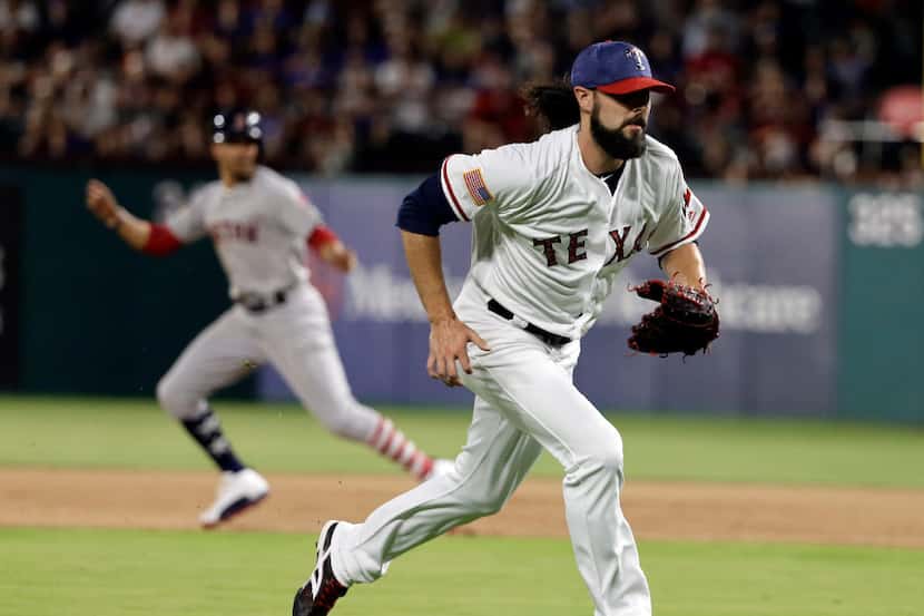 Texas Rangers relief pitcher Tony Barnette, sprints to the plate to cover after throwing a...
