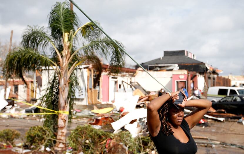 A woman looks at the wreckage caused by a tornado that touched down along Chef Menteur...