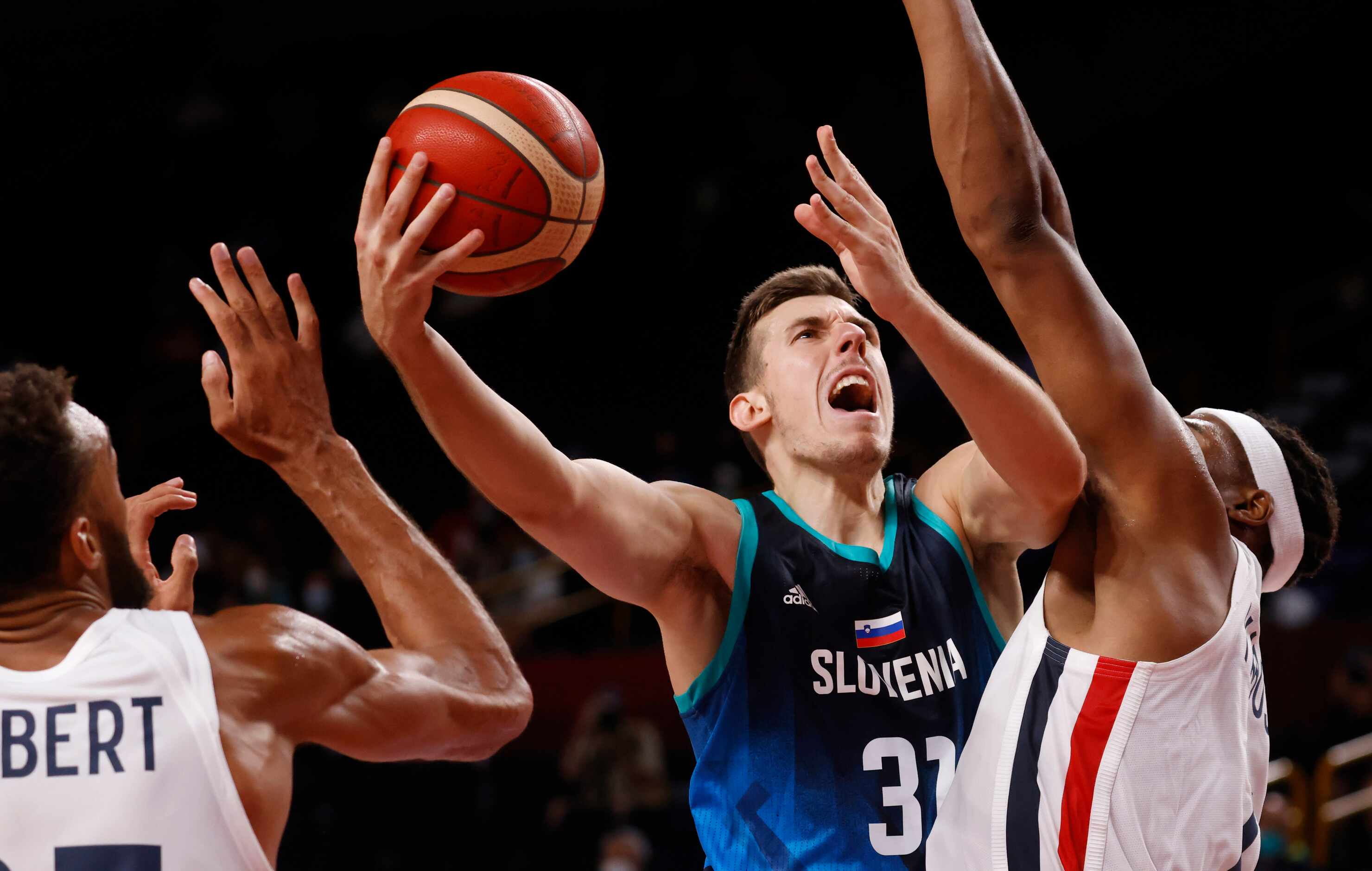 Slovenia’s Vlatko Cancer (31) attempts a shot in between France’s Rudy Gobert (27) and...