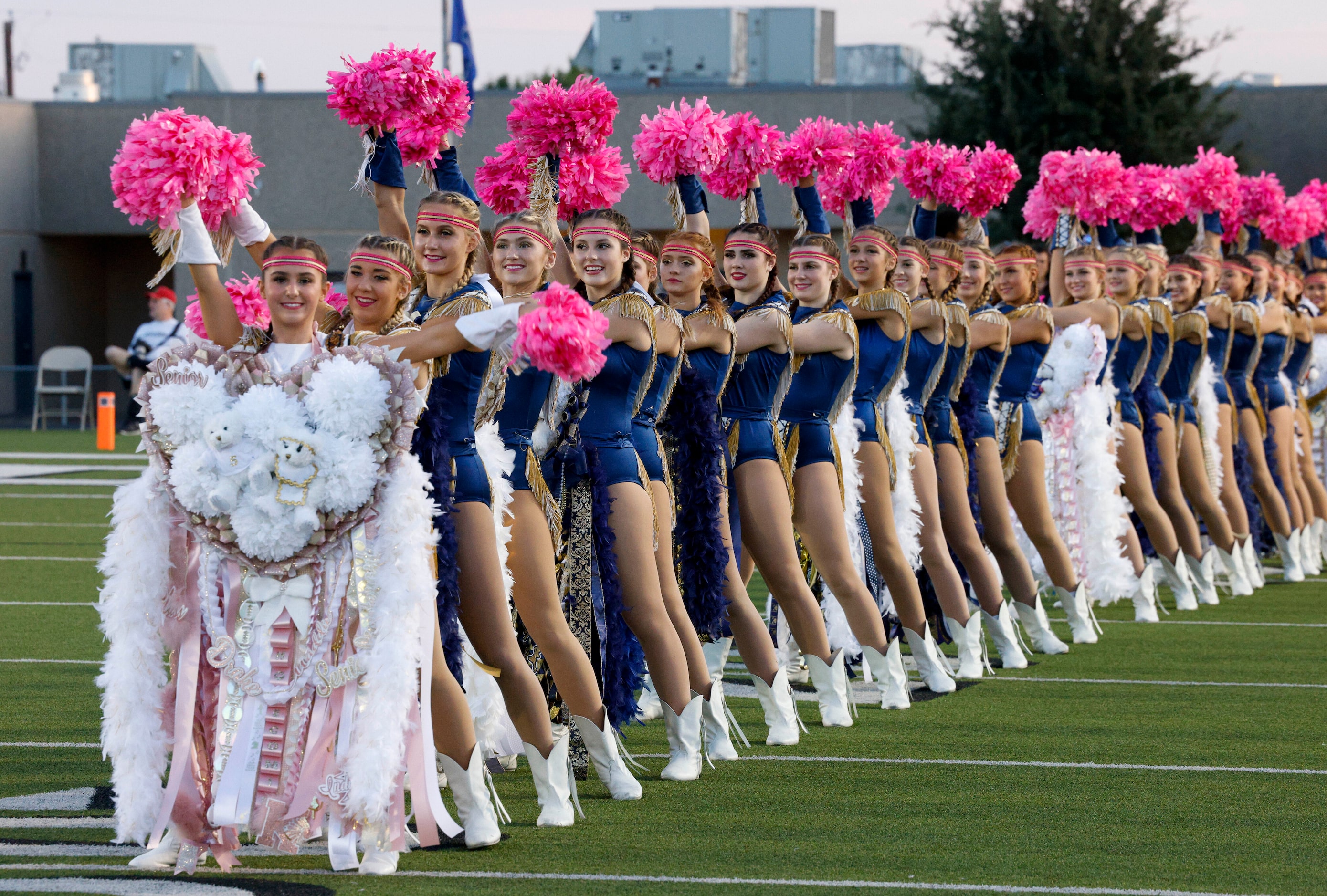 The Keller High School Indianettes perform while wearing their homecoming mums before a game...