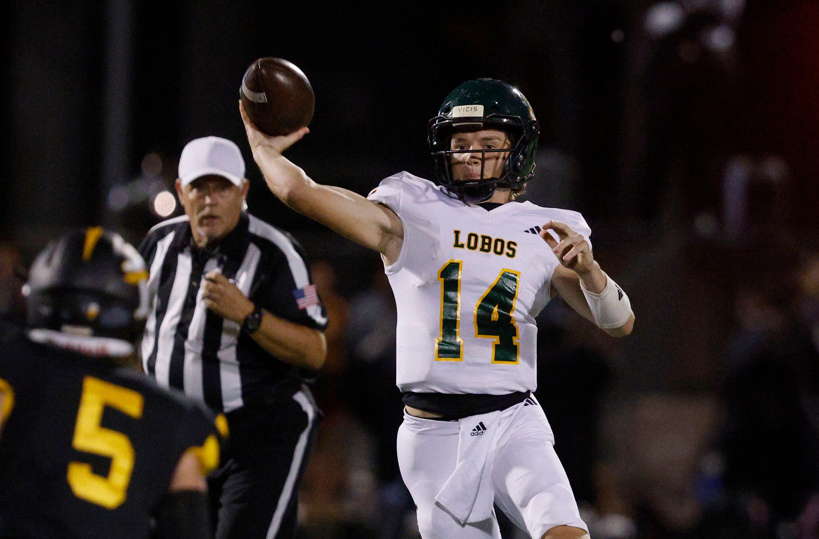 Longview's quarterback Andrew Tutt (14) passes under pressure from Forney's Easton McMillan...