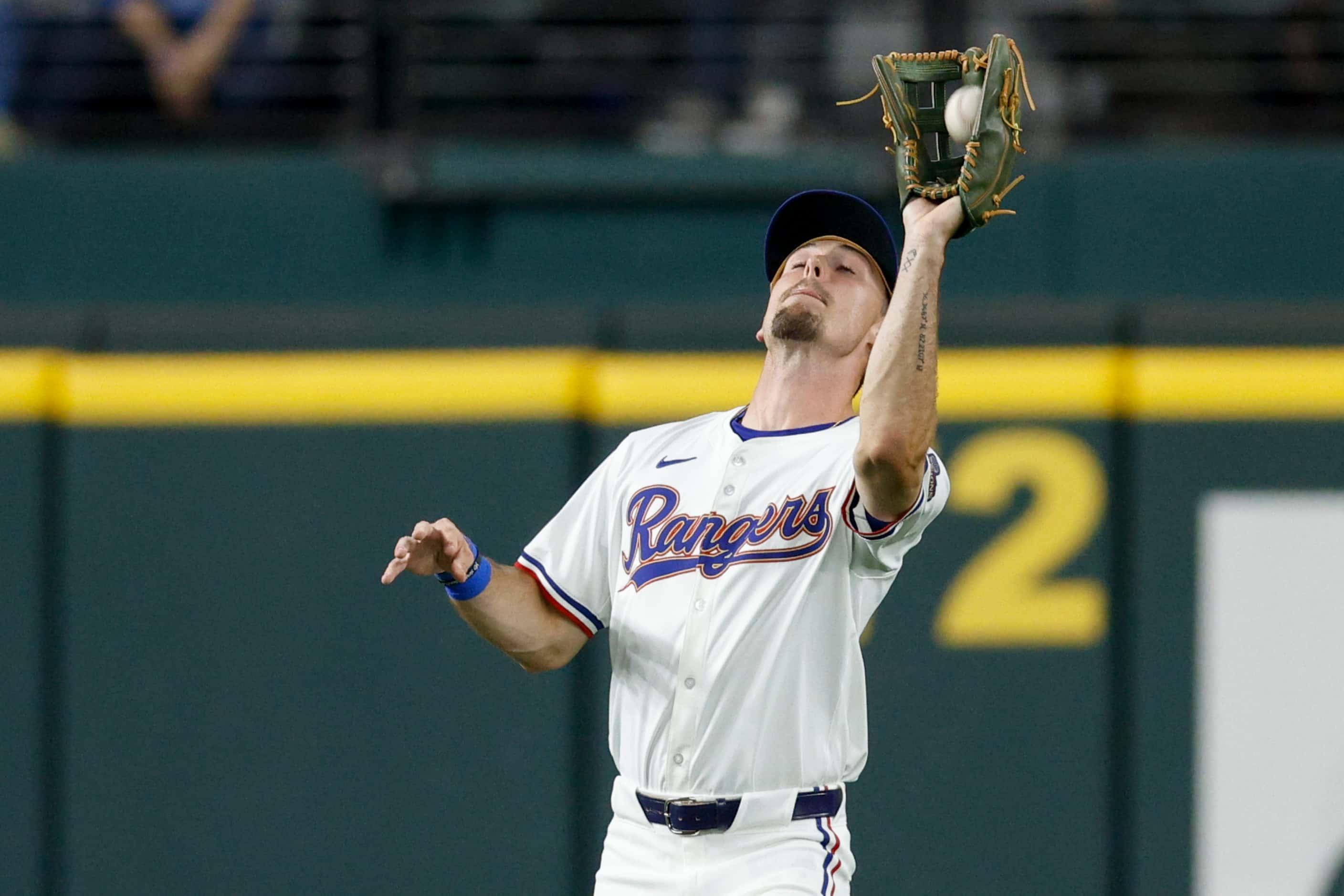 Texas Rangers left fielder Evan Carter (32) catches a fly ball of the bat of Chicago Cubs...