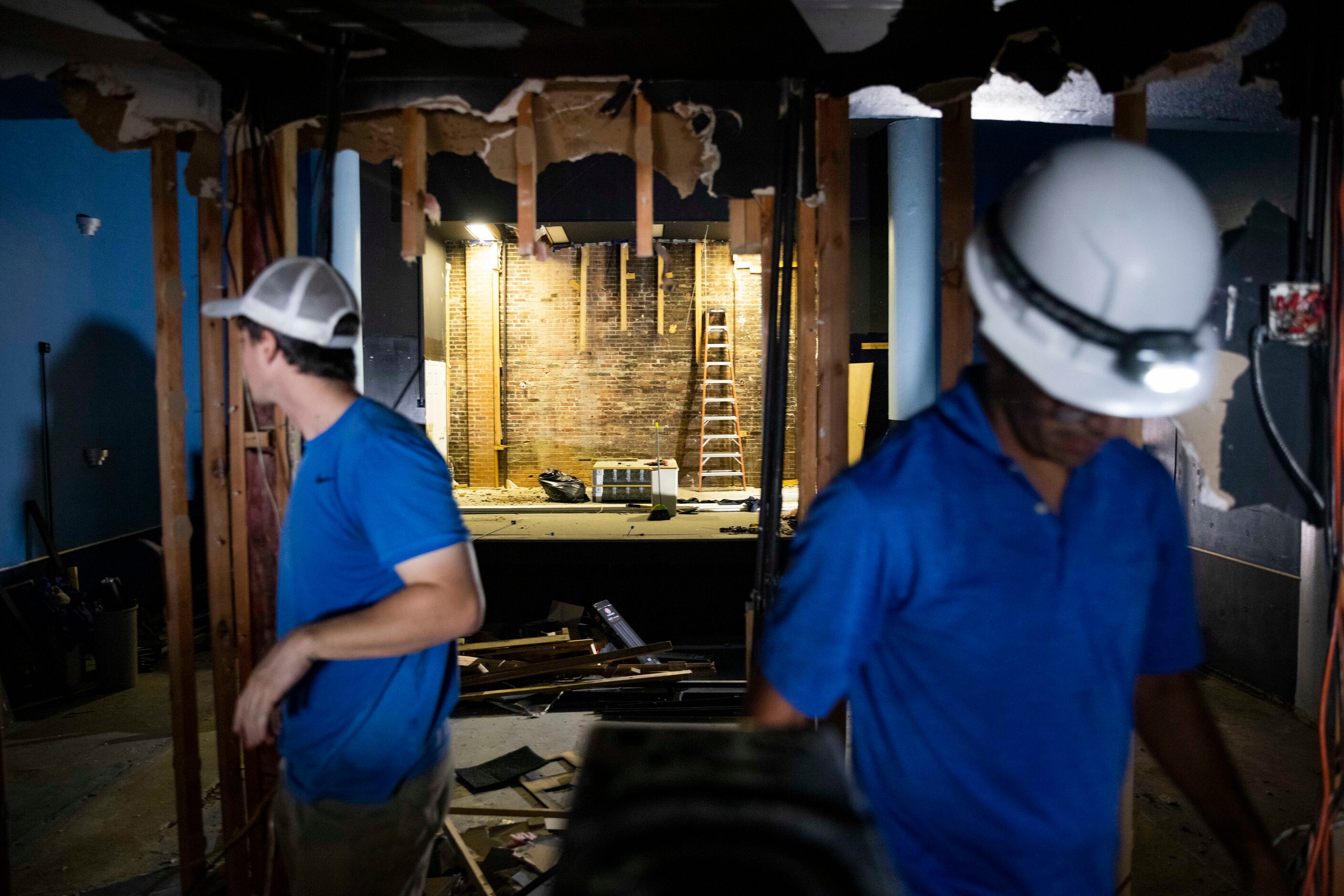 Rex Johnson (left) and Omar Flores work to remove the old sound booth in the The Texas...