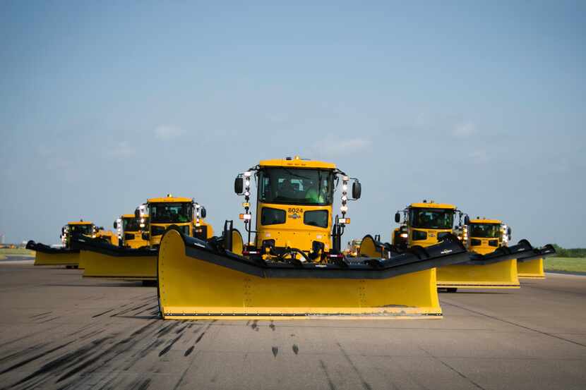 Snowplows make their way down a runway during a training session at DFW International Airport.