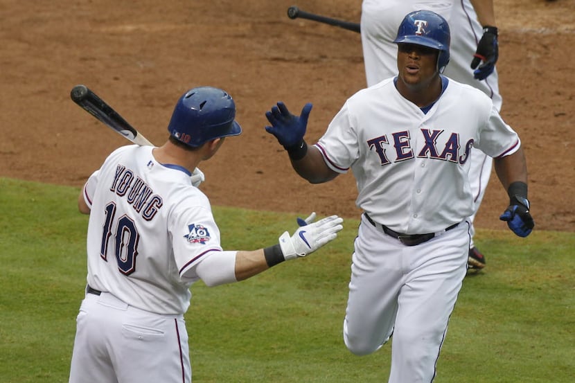 Texas Rangers third baseman Adrian Beltre (29) is congratulated by  Michael Young (10) after...