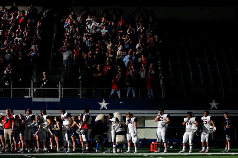 Allen players and fans stand for the national anthem before a game against South Grand...
