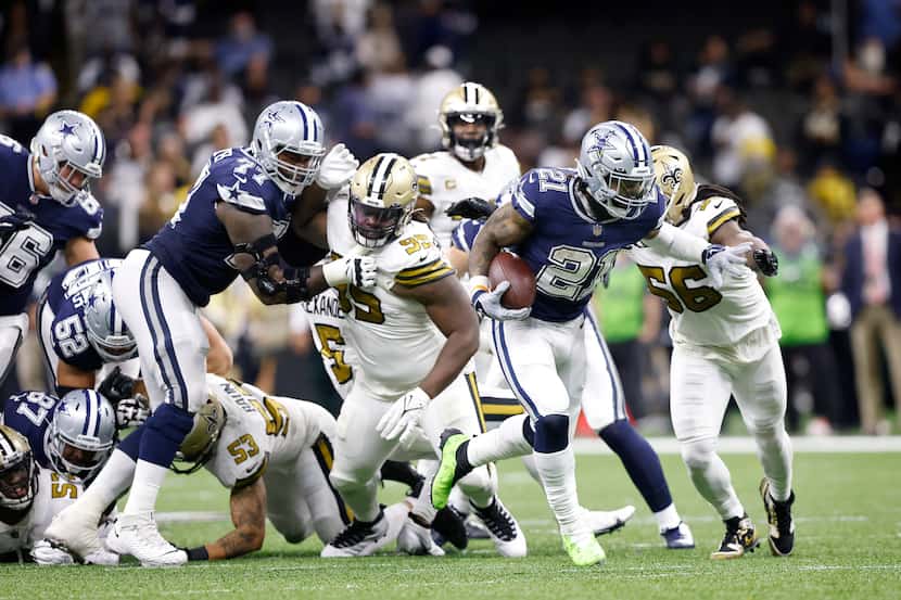 Dallas Cowboys running back Ezekiel Elliott (21) busts through the New Orleans Saints...