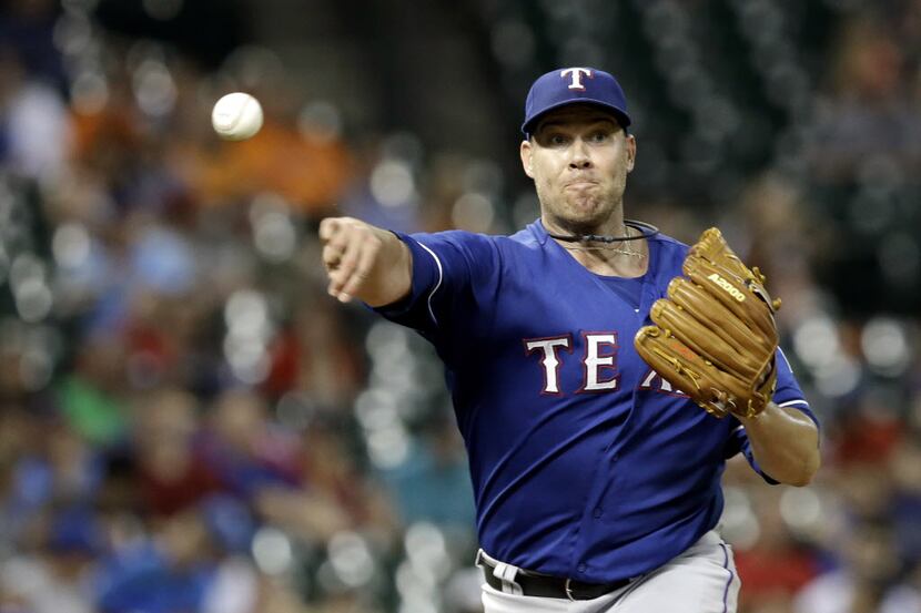 Texas Rangers' Colby Lewis throws to first base trying for a pickoff on Houston Astros'...