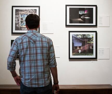 A man looks at photographs by Dallas Morning News photo editor Guy Reynolds at Kettle Art...