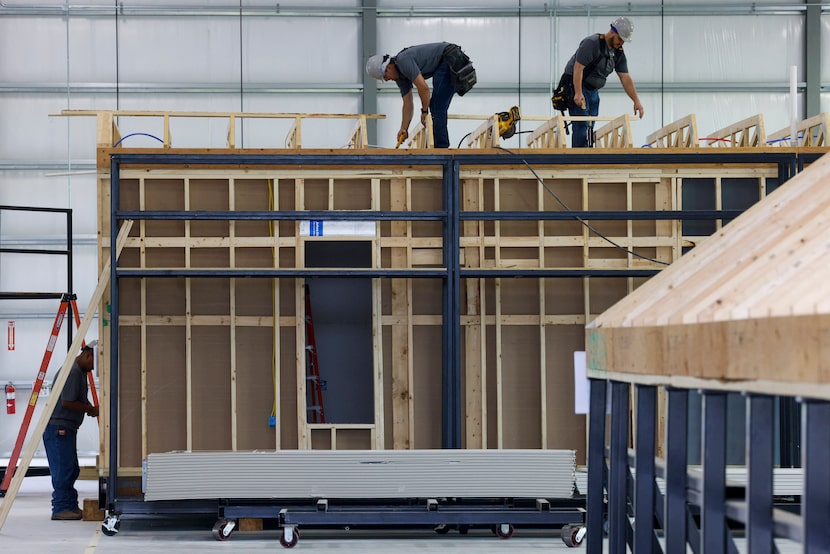 Construction crews work on a home at HiFAB’s modular home factory in Grand Prairie.