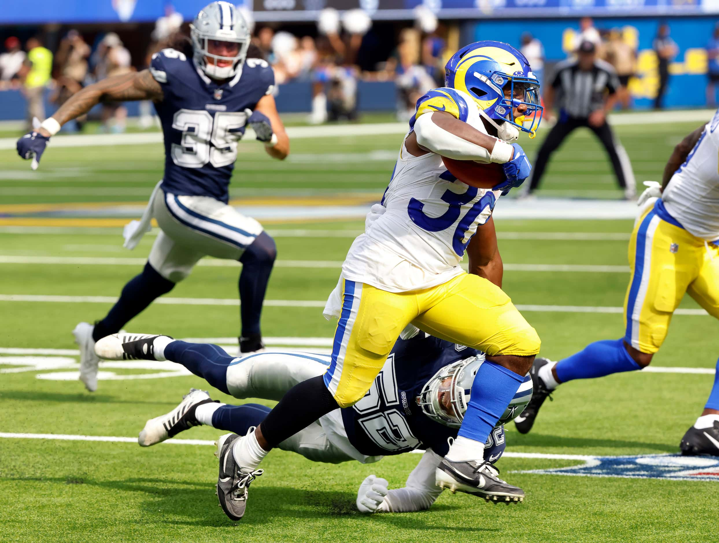 Dallas Cowboys linebacker Byron Vaughns (52) attempts a tackle of Los Angeles Rams running...