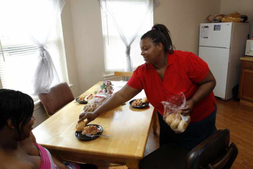 Jackie Eaton (center) sets the table in her Cedar Hill home for lunch with her family,...