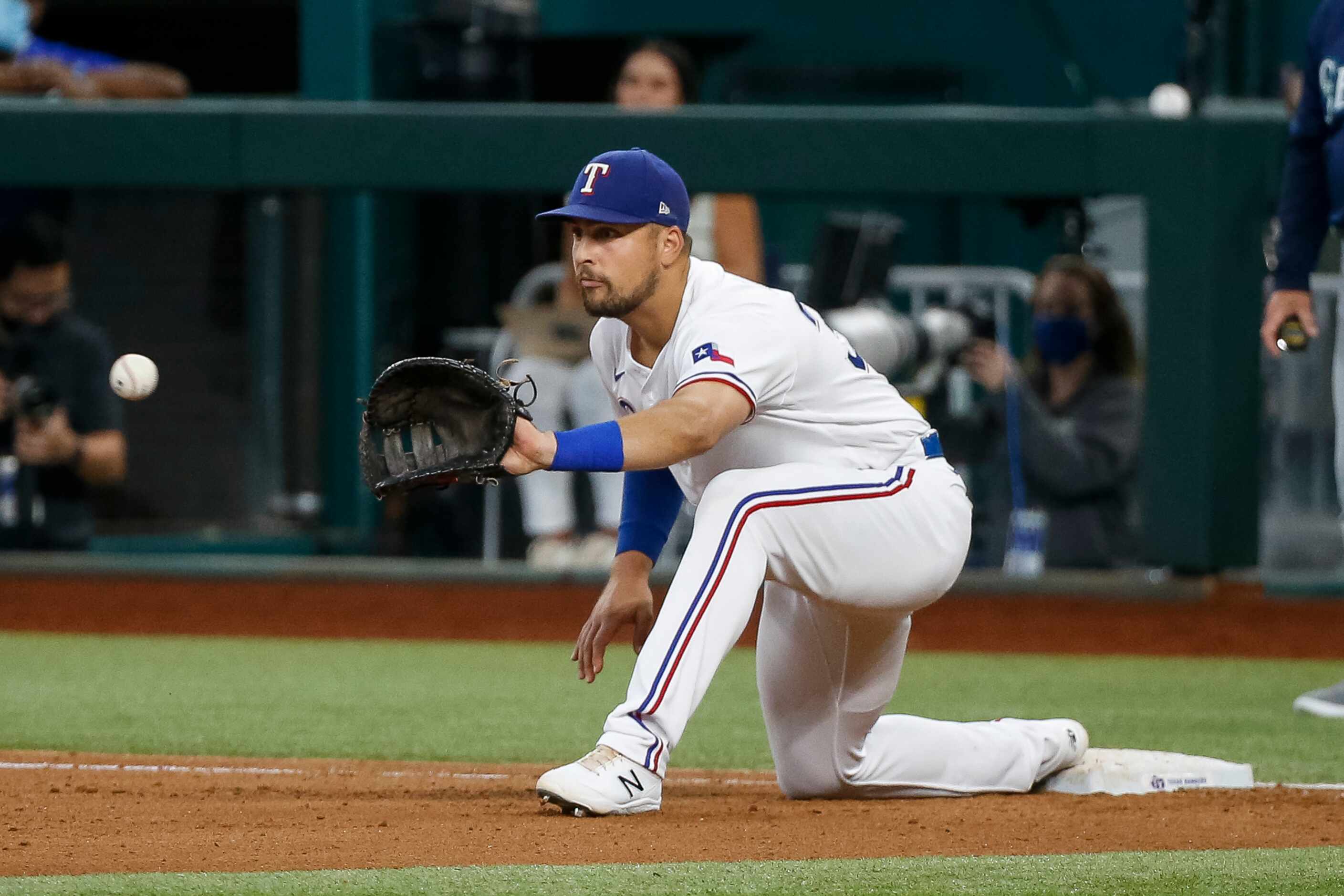 Texas Rangers first baseman Nathaniel Lowe (30) reaches to record an out during the fourth...