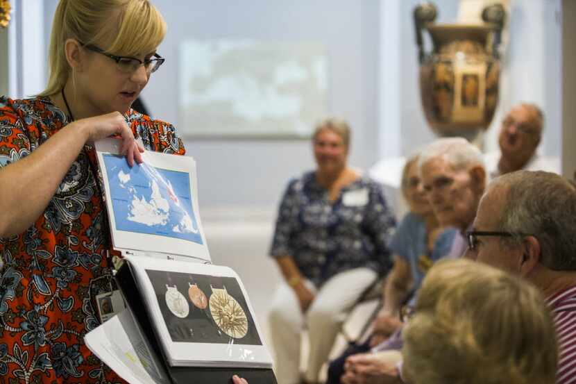 Emily Wiskera, manager of access programs, shows photos of Olympic medals during a...