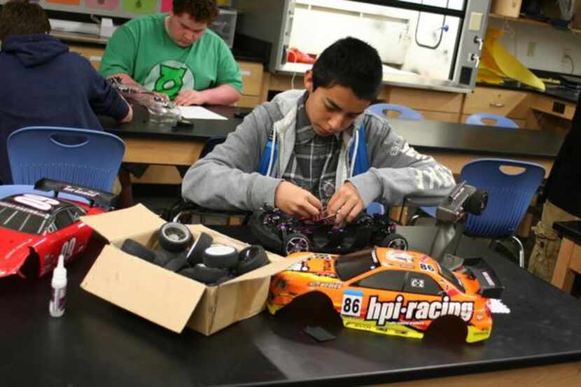 
R.L. Turner High School freshman Jonathan Perez makes adjustments to a radio-controlled car...