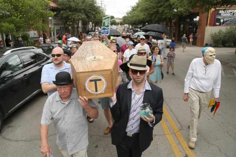 
Pallbearers Ed Meyer (left) and Patrick Kennedy carried a fake coffin in the Bishop Arts...