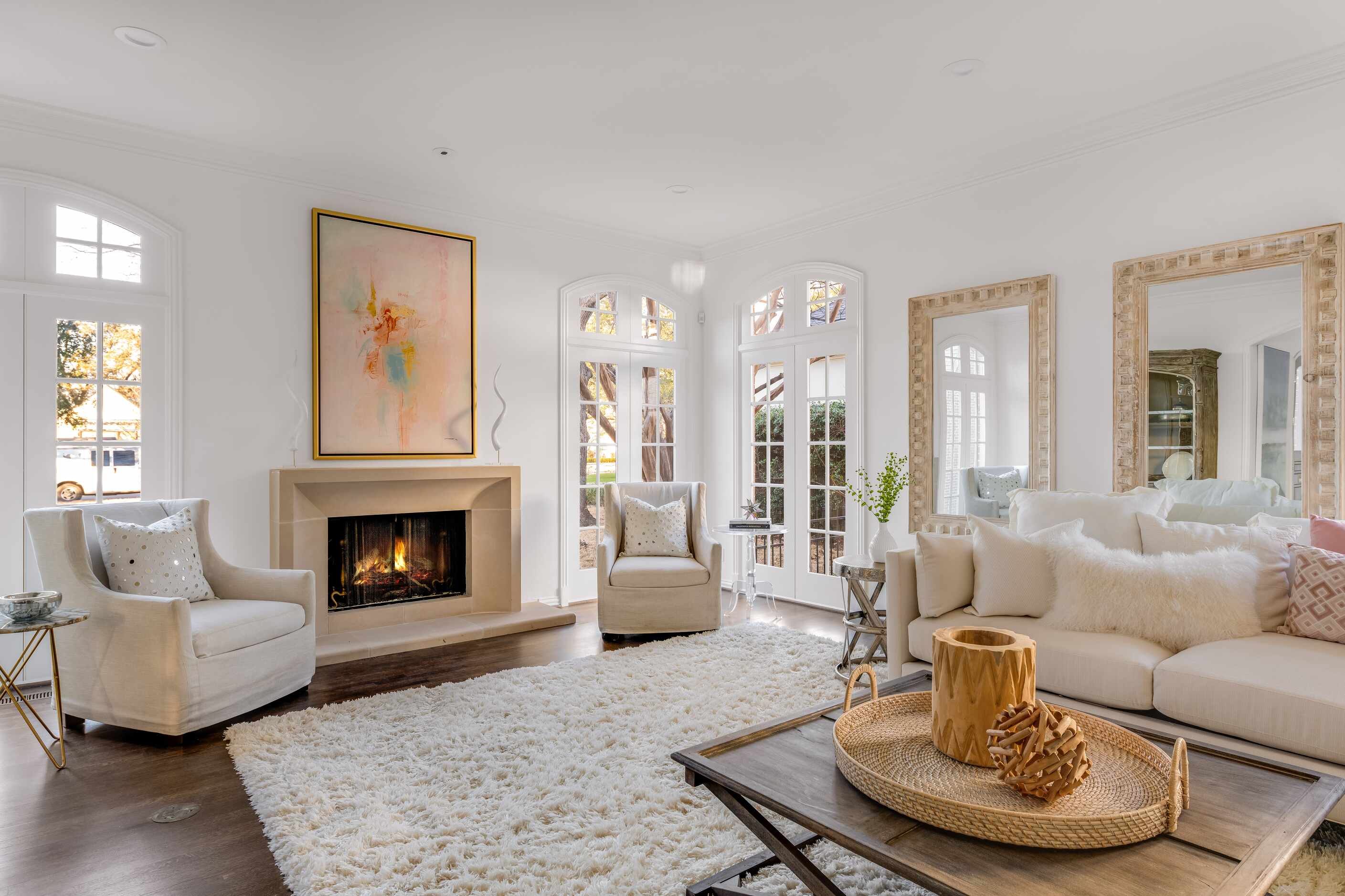 A living room faces a fireplace and has floor-to-ceiling French doors.