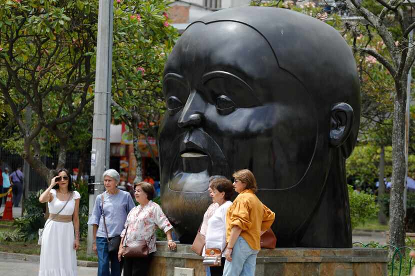 People pose for photos in front of a sculpture by Colombian artist Fernando Botero at Botero...