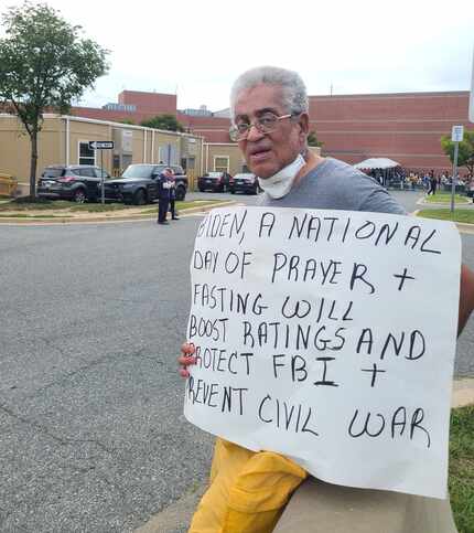 Rocky Twyman of Rockville, Md., holds a sign calling for a day of prayer and fasting to...