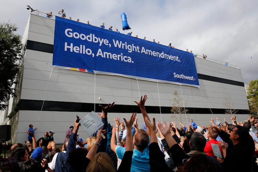 Hundreds of Southwest Airlines employees wave their hands as other employees throw t-shirts...