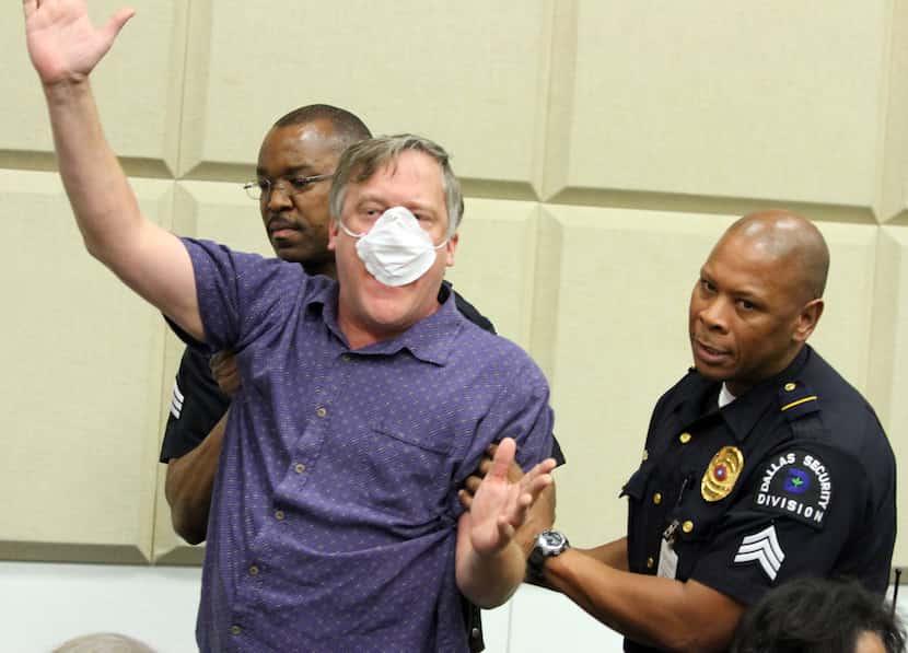 Protester Pete Rokicki was escorted out of Dallas City Hall during a briefing from the...