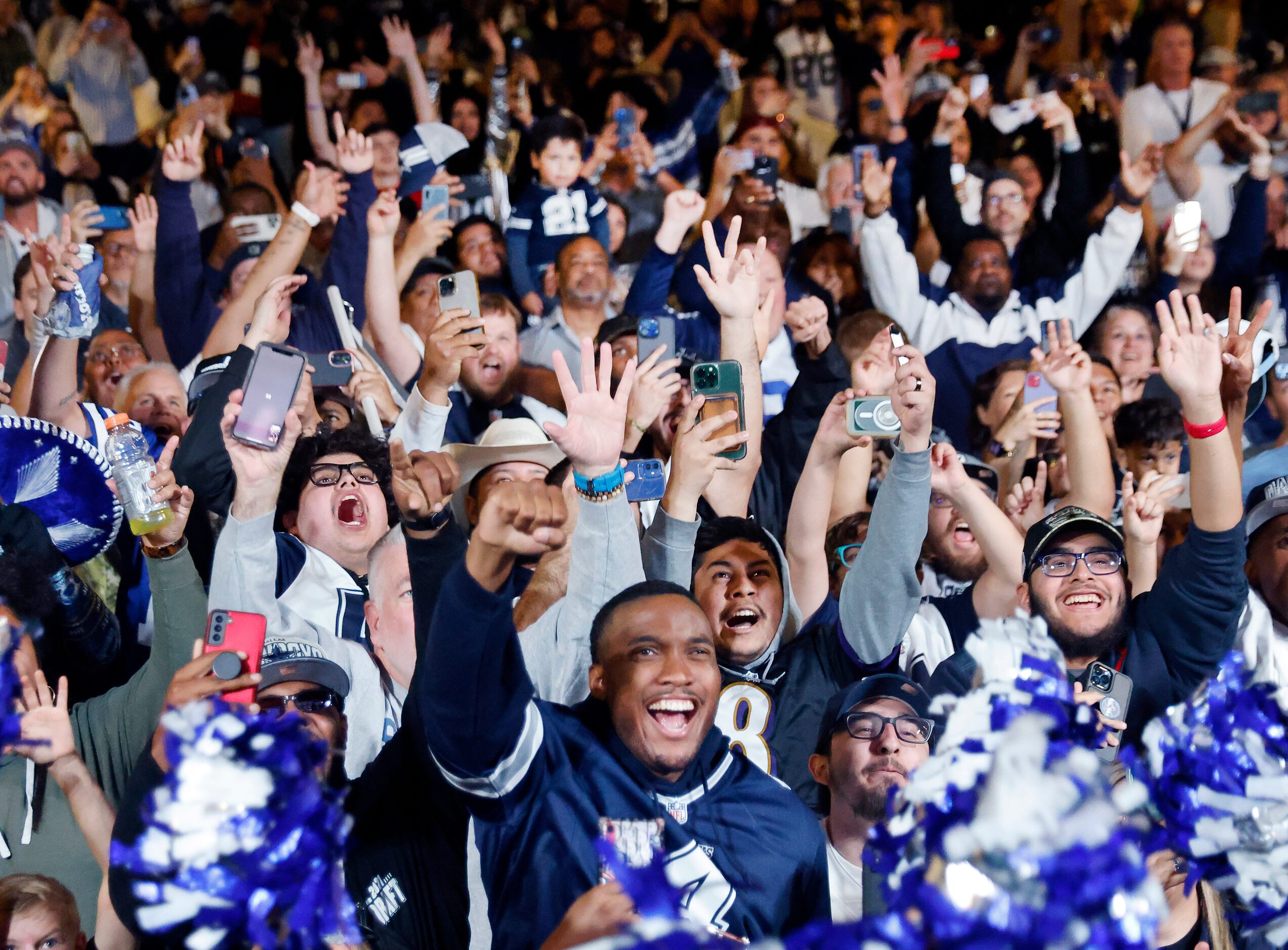 Dallas Cowboys fans cheer the teams first round pick in the NFL Draft during a draft party...