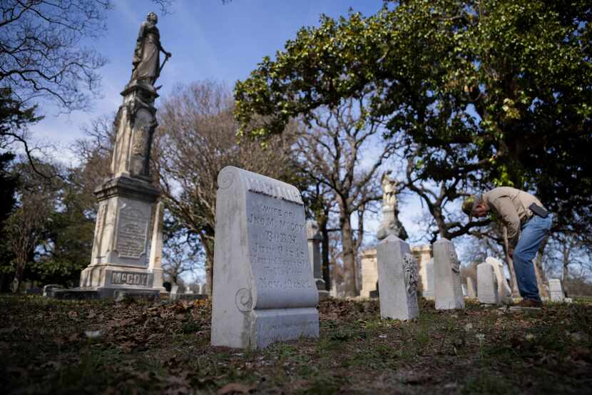 Volunteer Tom White looked Tuesday at one of the headstones in the McCoy family plot, which...