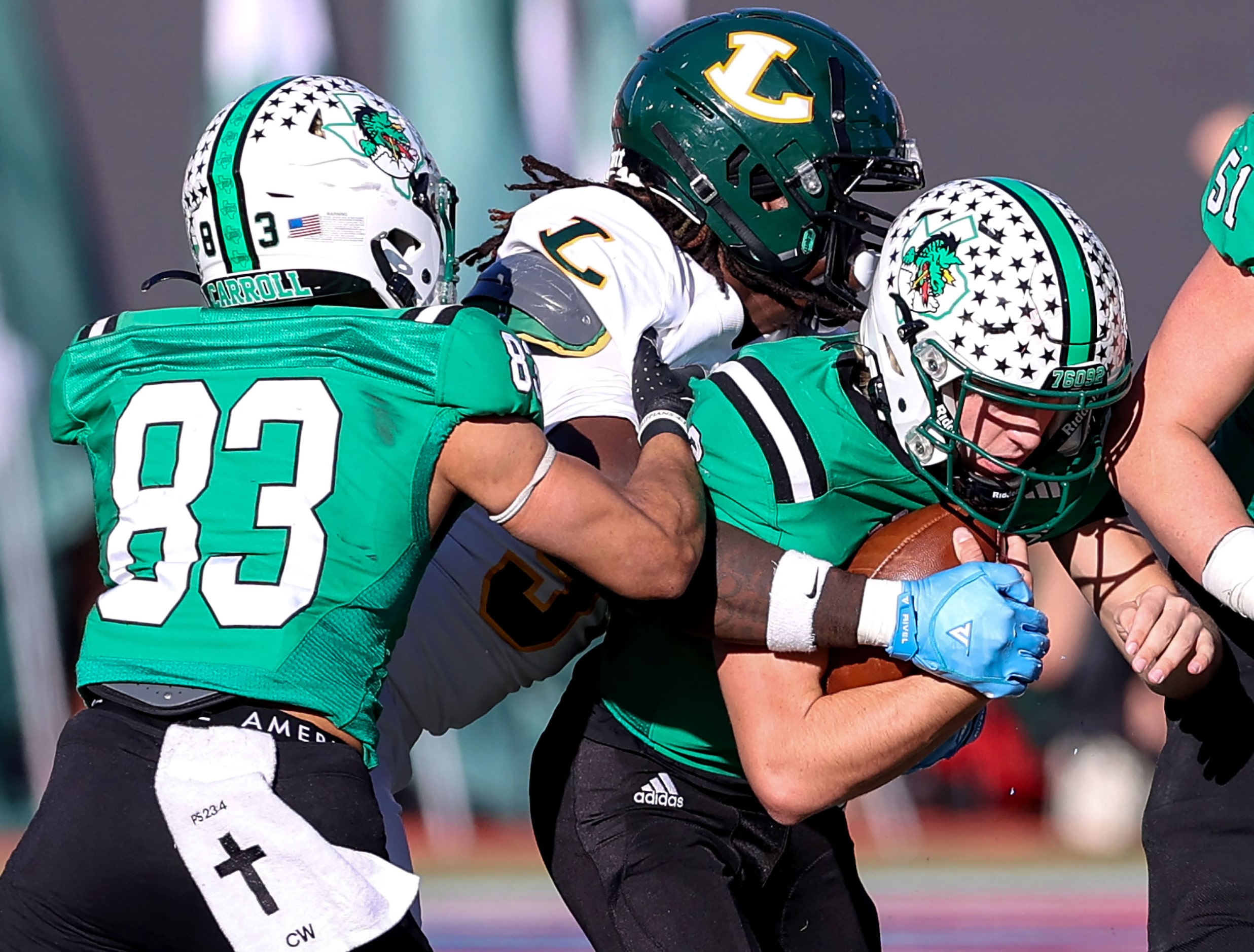 Southlake Carroll quarterback Angelo Renda (center) gets sacked by Longview defensive...