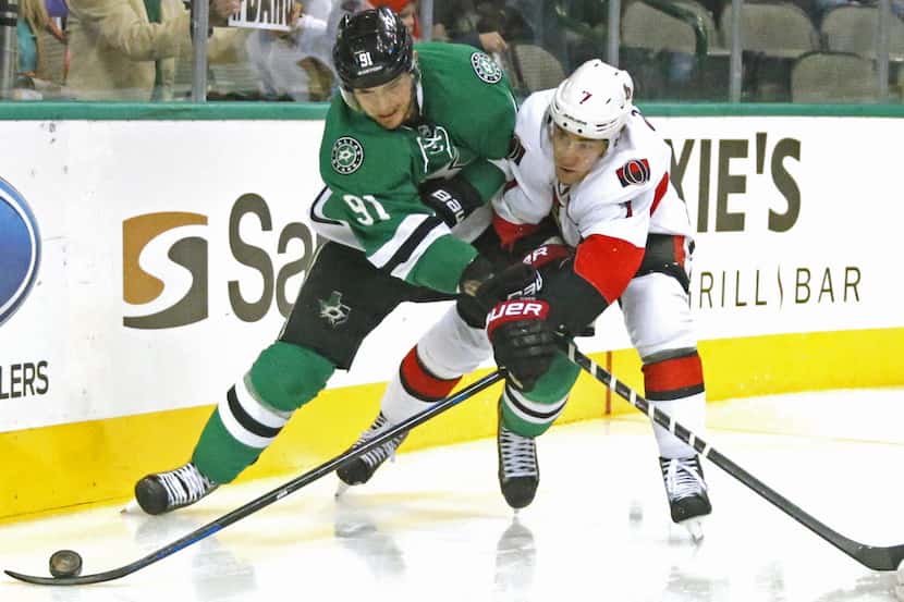 Dallas' Tyler Seguin (91) fights for the puck behind the net with Ottawa's Kyle Turris (7)...