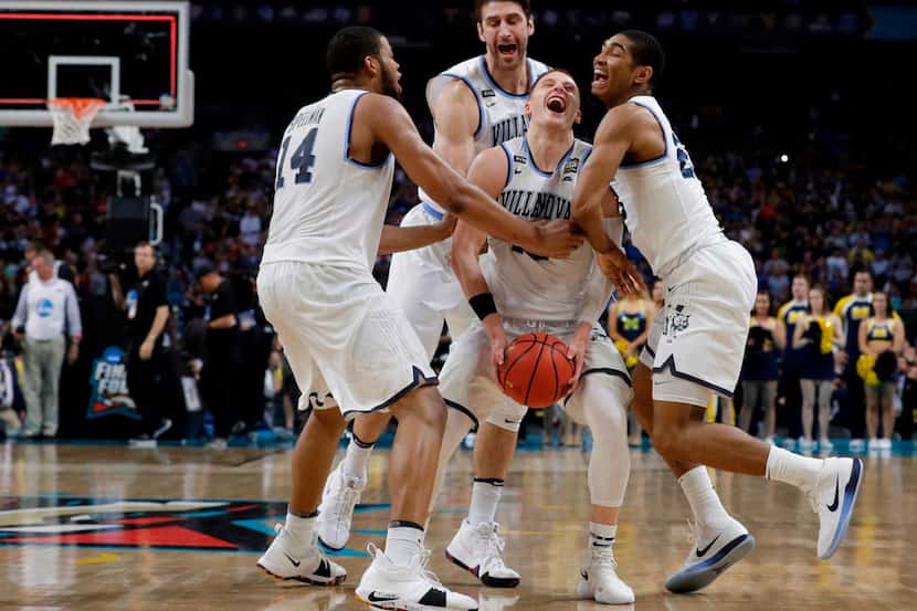 Villanova guard Donte DiVincenzo, center, celebrates with teammates at the end of the...