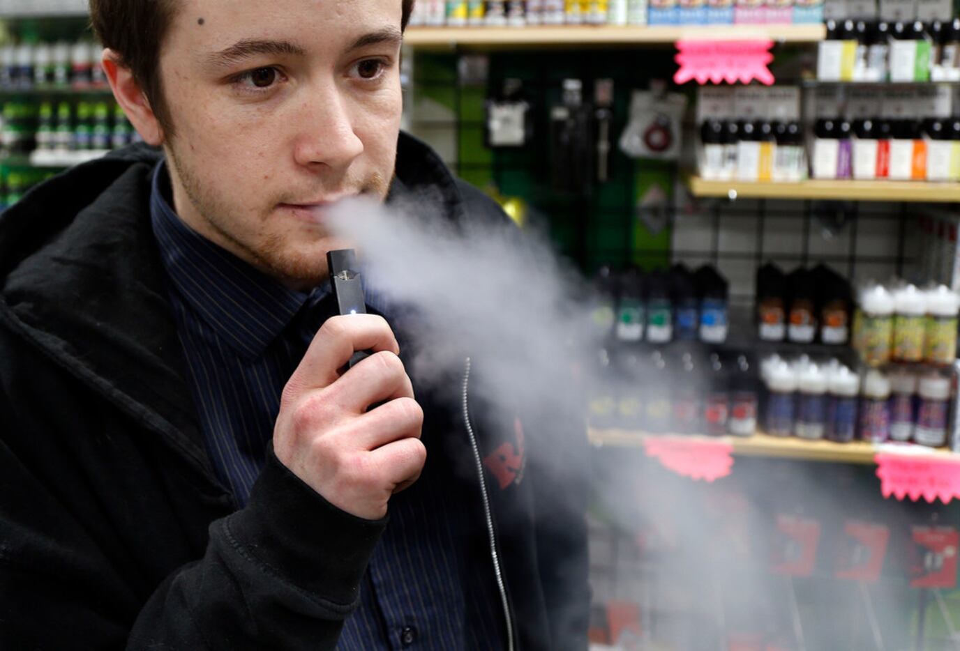 Nick Gregory, a 26-year-old manager, vapes on a JUUL at Botany Bay in Lexington, Ky. Several...