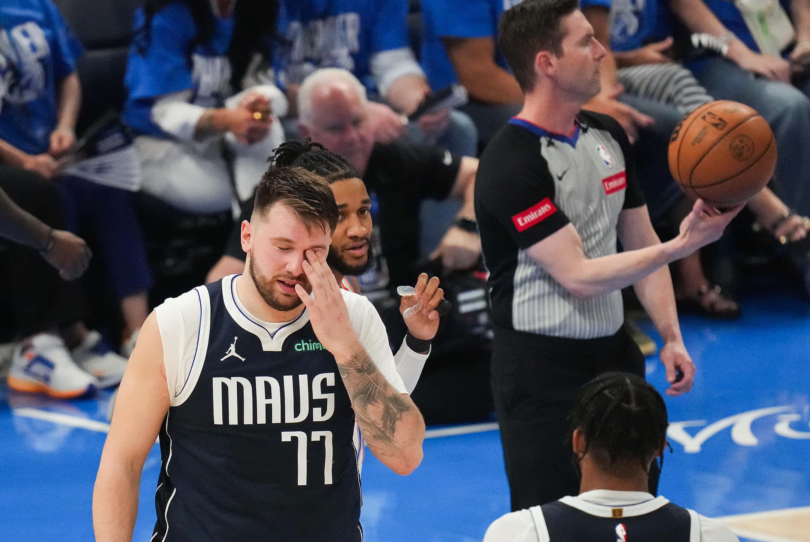 Dallas Mavericks guard Luka Doncic (77) rubs his eye after being fouled during the first...