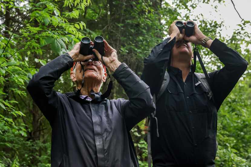 Father Tim Gollob, left, and naturalist Ben Sandifer look more closely with binoculars after...
