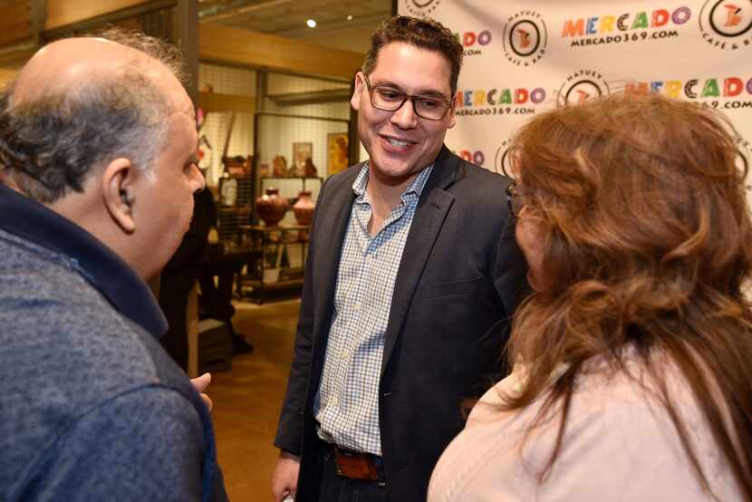 Dallas City Council candidate for District 1, Giovanni Valderas, centers, speaks with Jesse...