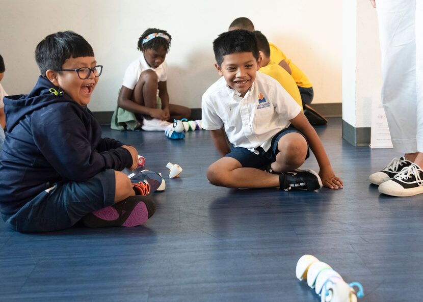 A group of campers enjoy the success of their coding worm at the Perot Museum.