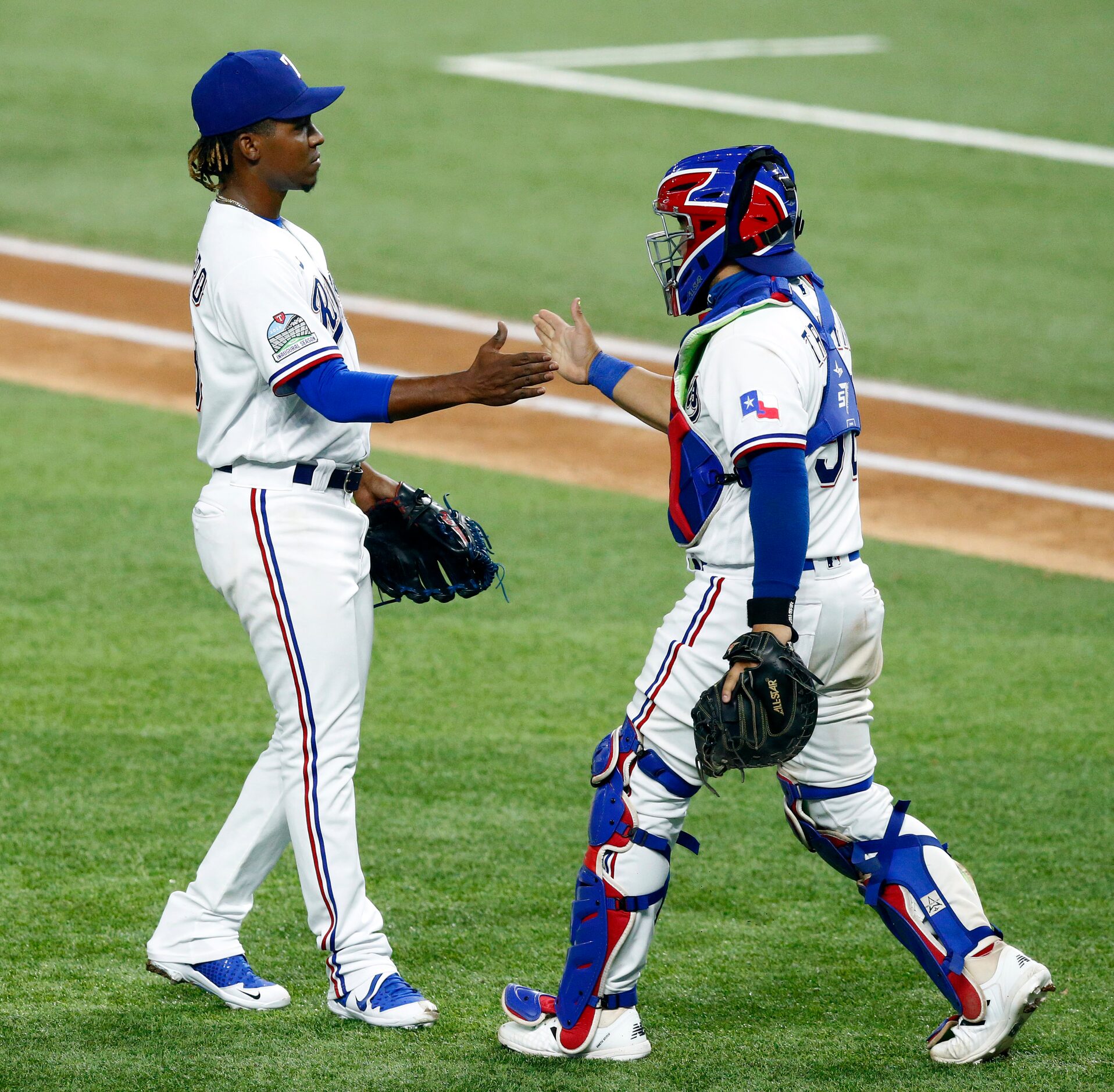 Texas Rangers relief pitcher Rafael Montero (left) is congratulated on his save in the ninth...