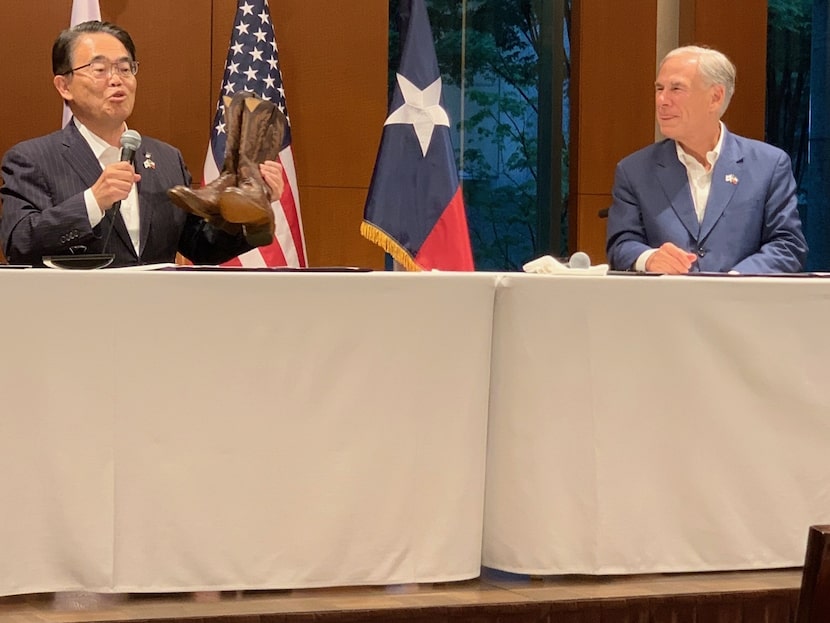 In Tokyo, Texas Gov. Greg Abbott presents a pair of brown Lucchese boots to Hideaki...