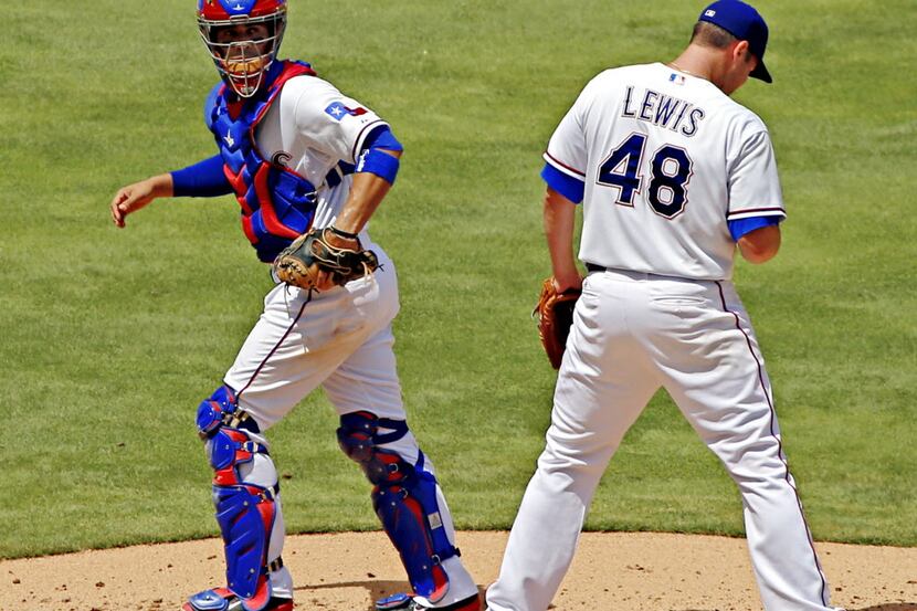 Texas Rangers catcher Robinson Chirinos (left) heads back to the plate after trying to talk...